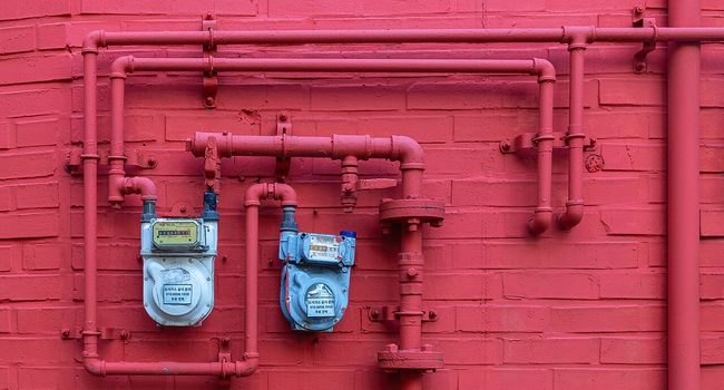 Two water meters on a red brick wall